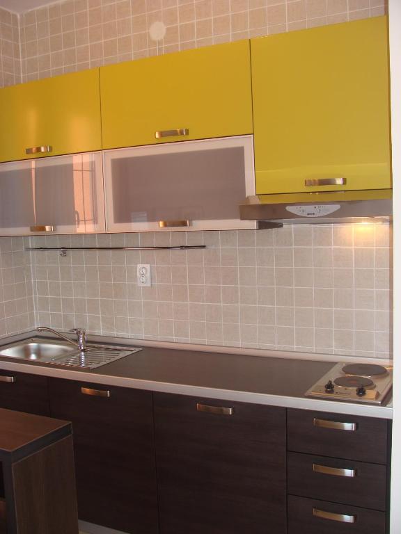 a kitchen with a sink and yellow cabinets at Apartments Danilo Kažanegra in Sveti Stefan
