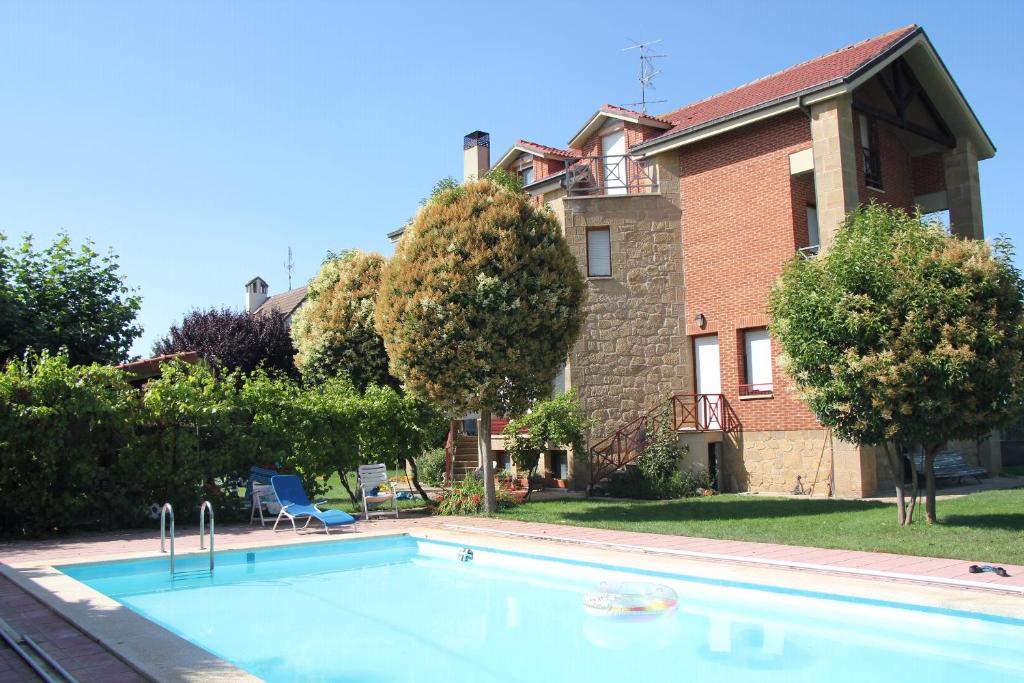 une grande piscine en face d'une maison dans l'établissement Preciosa casa independiente con piscina cubierta y gran jardín privados, à Haro