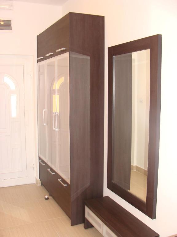 a brown cabinet with a mirror on a wall at Apartments Danilo Kažanegra in Sveti Stefan