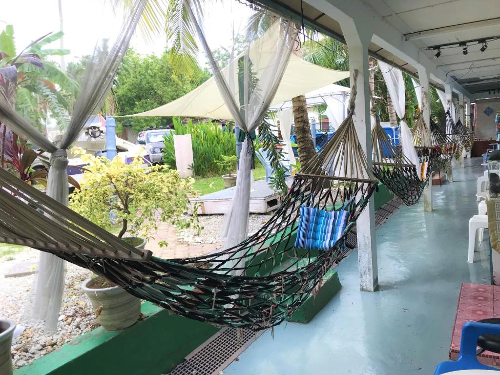 a hammock hanging from a building with a patio at Dar Yasmine Motel in Pantai Cenang