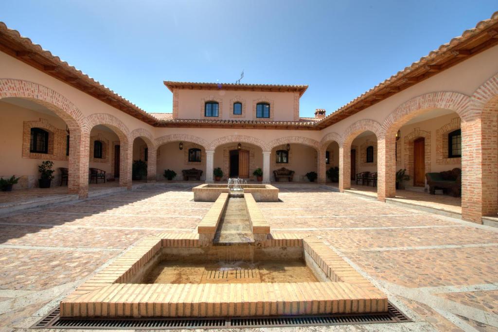 a courtyard with a fountain in front of a building at FINCA EL PIRUETANO in Toledo