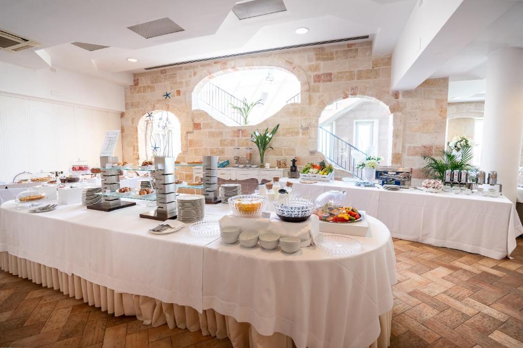 a large room with white tables with food on them at Covo dei Saraceni in Polignano a Mare