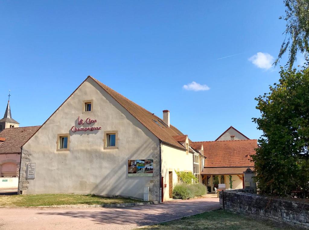 a white building with a sign on the side of it at Gite du Clos Champagnac in Chailly-sur-Armançon