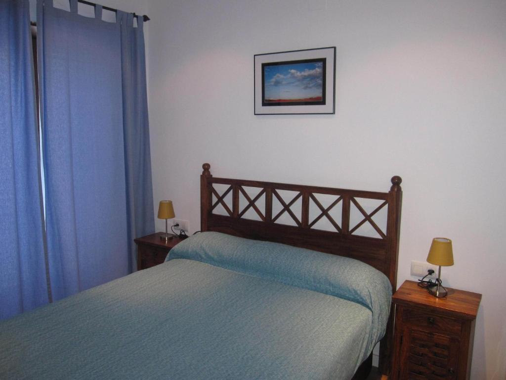 a bedroom with a bed and a picture on the wall at La Casita Azul De Chillaron in Chillarón de Cuenca