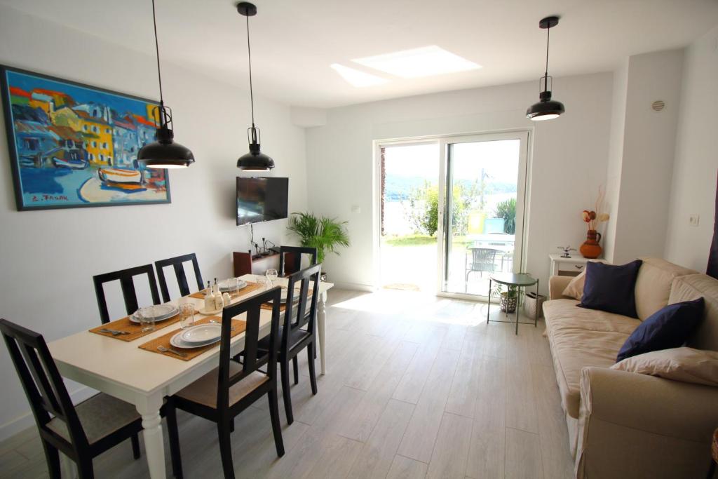 a living room with a table and chairs and a couch at Tramontana Leeward - Cozy and charming apartment in beautiful Volosko in Opatija