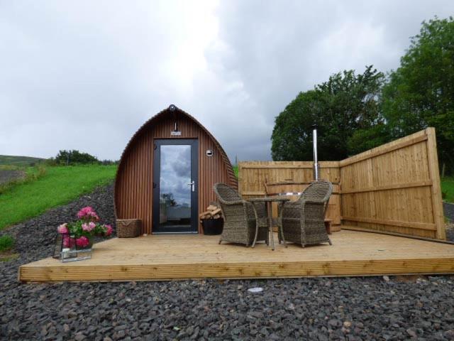 une terrasse en bois avec une table et des chaises devant un bâtiment dans l'établissement Peel Farm, à Craighall