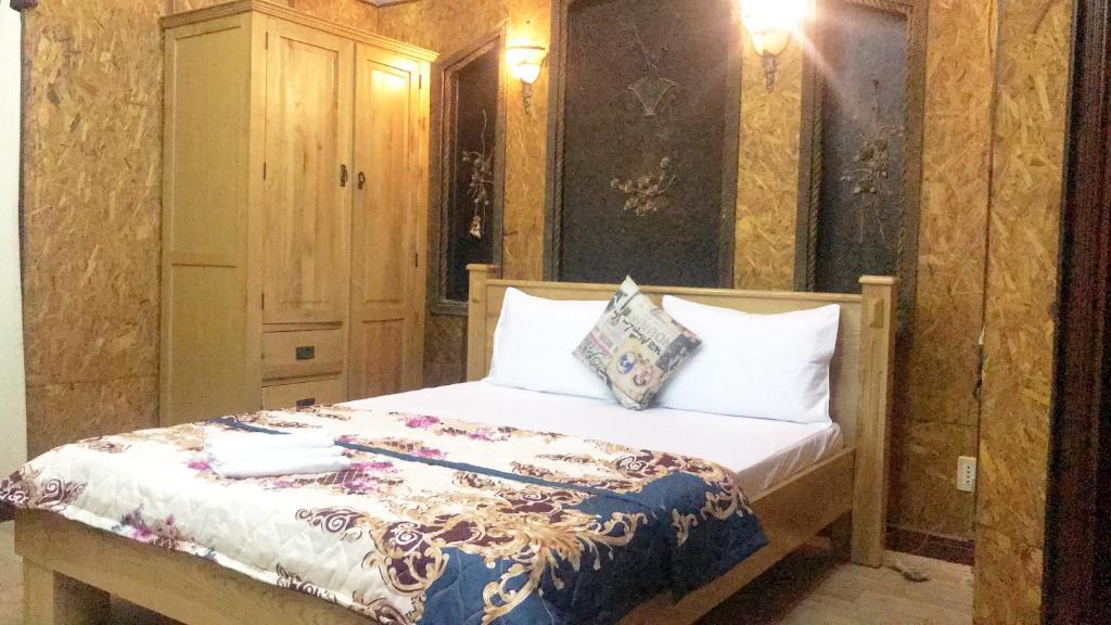 1 dormitorio con 1 cama con almohadas blancas en Nhật Vân 1 en Ho Chi Minh