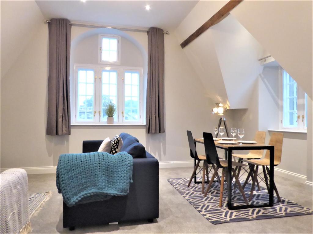 a living room with a table and a chair at Town Hall Lofts, Settle in Settle