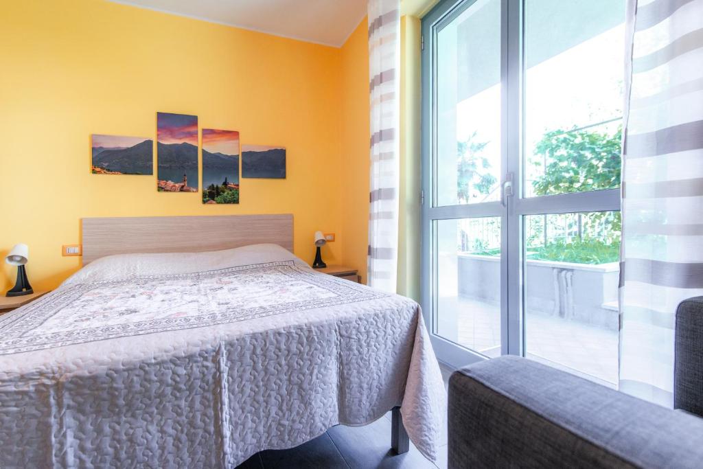 a bedroom with a bed and a large window at Casa Livio - Rooms and studios in Como