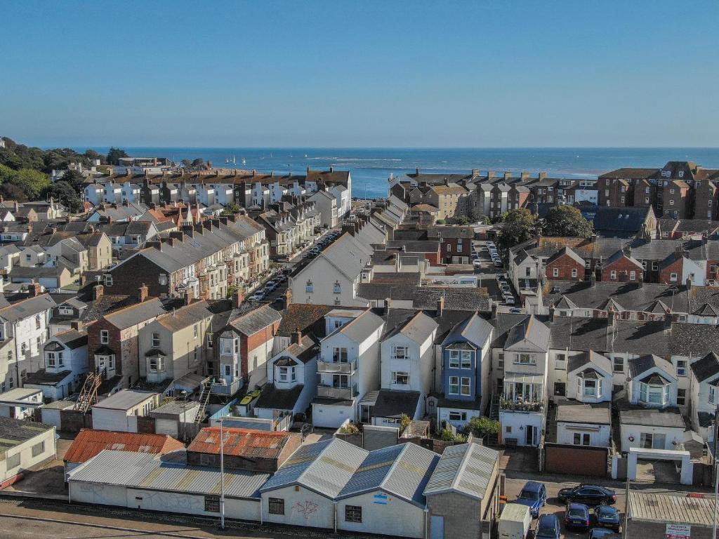 una vista aerea di una città con case e l'oceano di Sunnymead Penthouse, Exmouth a Exmouth