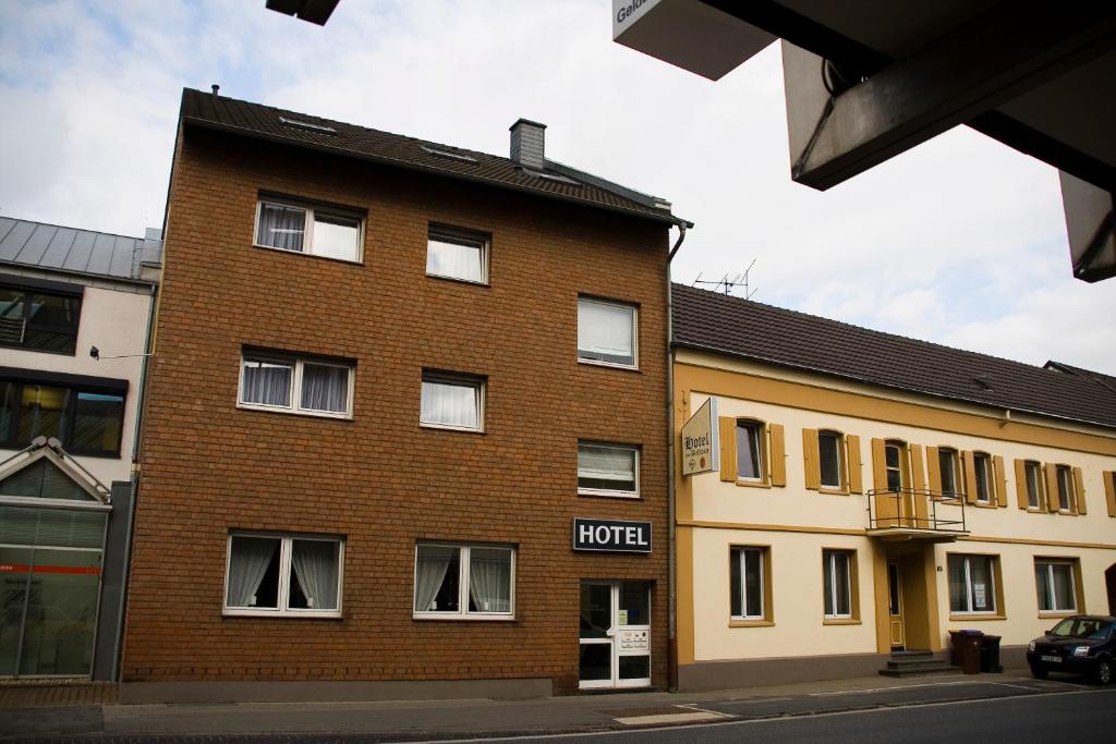 ein Backsteingebäude mit einem Schild an der Seite des Hotels in der Unterkunft Hotel zum Schwan Weilerswist in Weilerswist