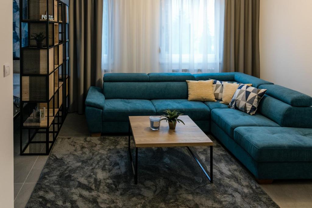 ein Wohnzimmer mit einem blauen Sofa und einem Couchtisch in der Unterkunft TODOR APARTMENTS Center in Banja Luka