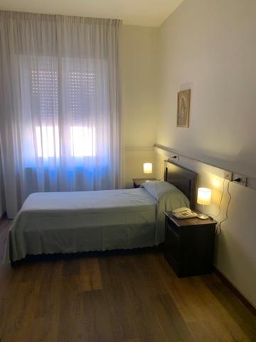 a bedroom with a bed and a window at Casa per Ferie Suore Domenicane in Rome