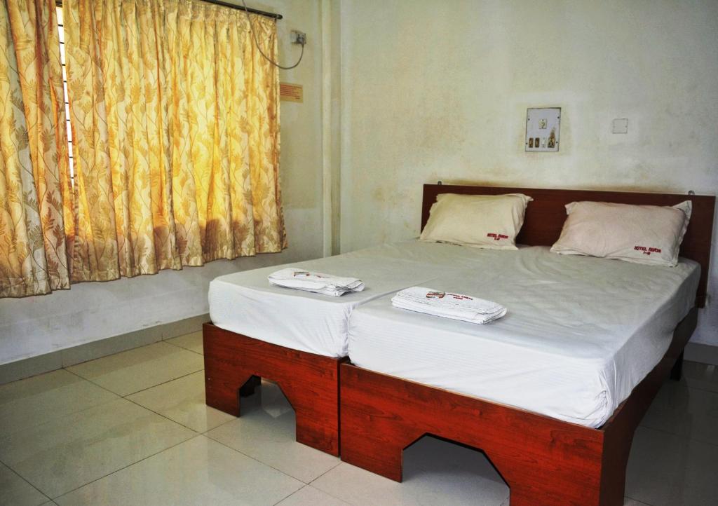 un letto con due asciugamani sopra in una stanza di Hotel Surya a Mangalore