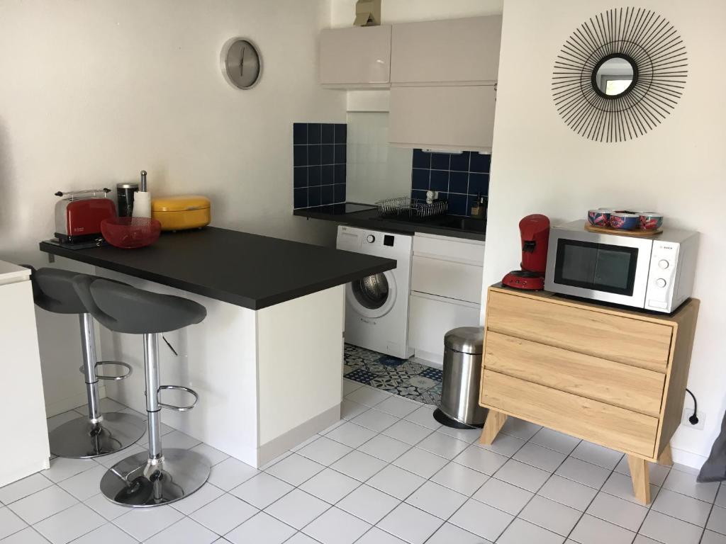 eine Küche mit einer Arbeitsplatte und einer Mikrowelle in der Unterkunft Appartement T2 refait à neuf, piscine in Quiberon