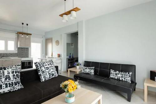 a living room with a black couch and a table at Bright Spacious Two-Bedroom Apartment in Thessaloniki