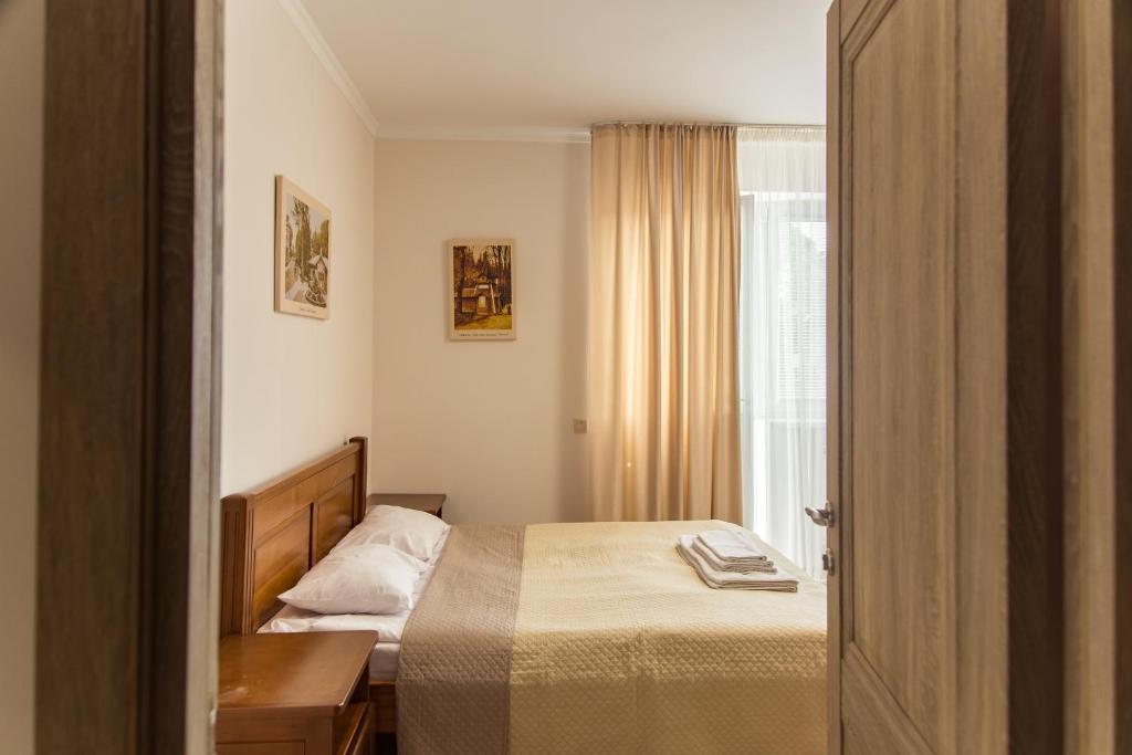 a small bedroom with a bed and a window at Villa ZHANNA Central park in Truskavets