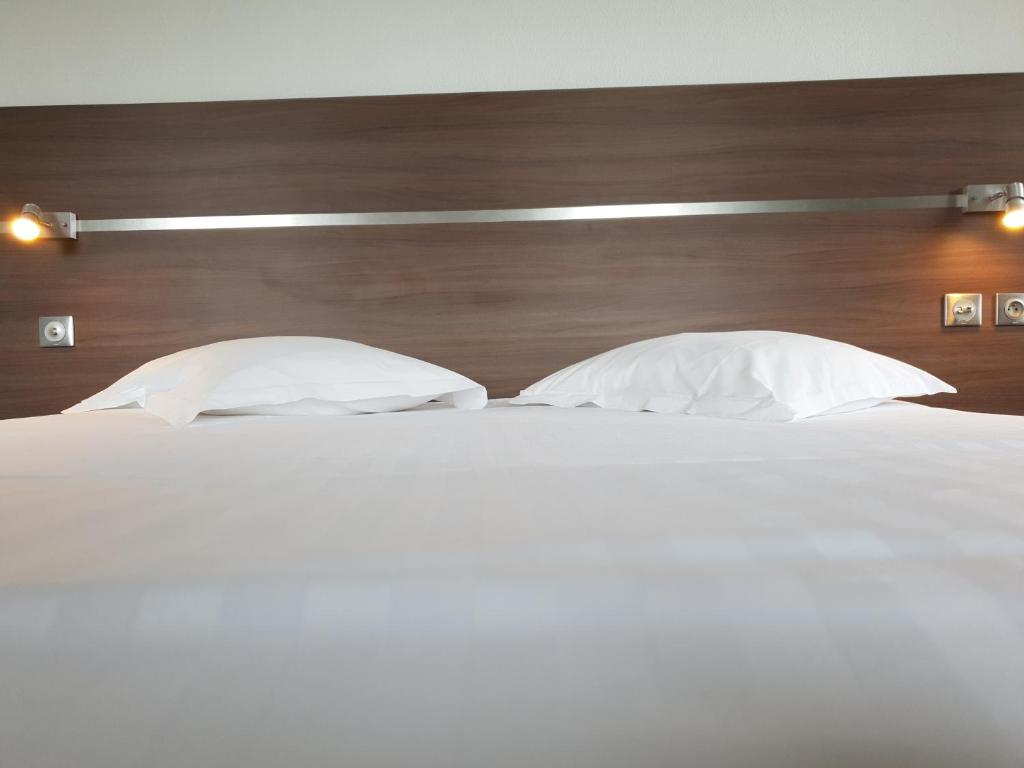 Postel nebo postele na pokoji v ubytování Grand Hôtel Bénodet Abbatiale Riviera Bretonne