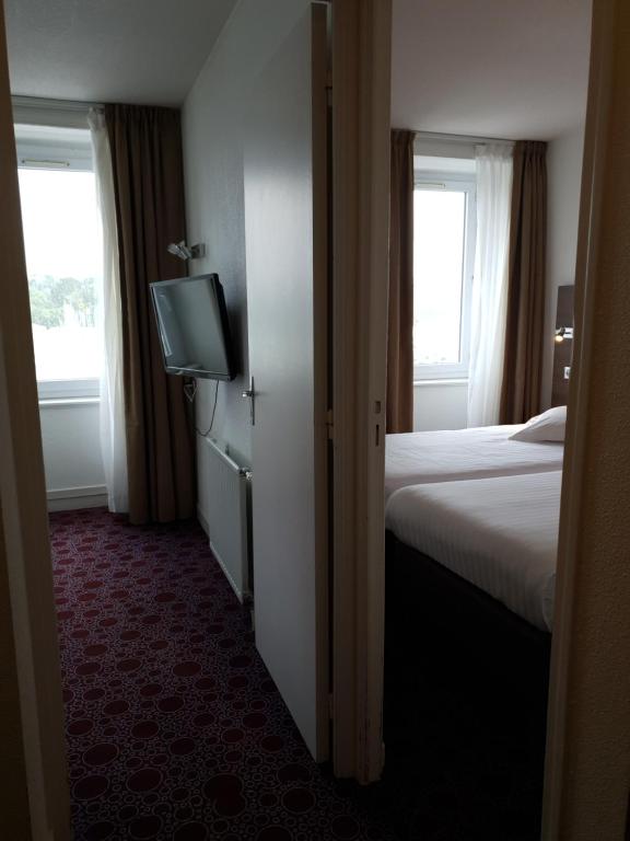 Postel nebo postele na pokoji v ubytování Grand Hôtel Bénodet Abbatiale Riviera Bretonne