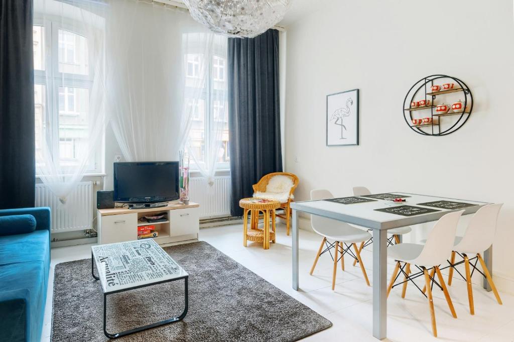 a white living room with a table and chairs at Apartament Miły in Gorzów Wielkopolski