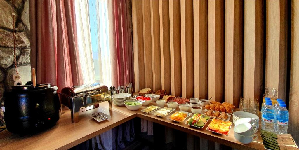 un tavolo con del cibo sopra in una stanza di Hotel Migu Yard a Kazbegi
