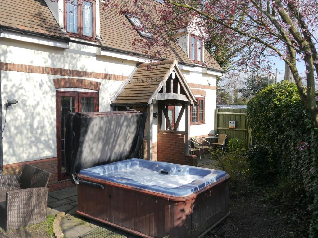 una bañera de hidromasaje en el patio trasero de una casa en Measure Cottage - Sleeps 5 - Private Hot tub and garden en Henley in Arden