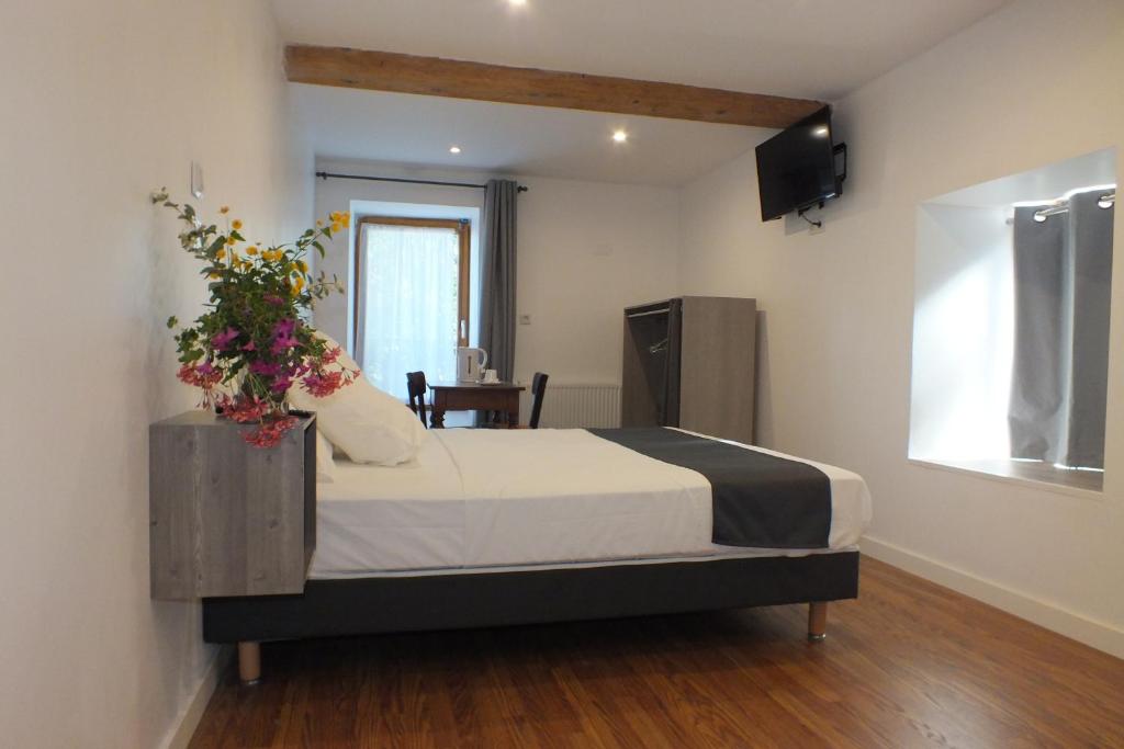 Un dormitorio con una cama con flores. en hotel du parc en Maclas