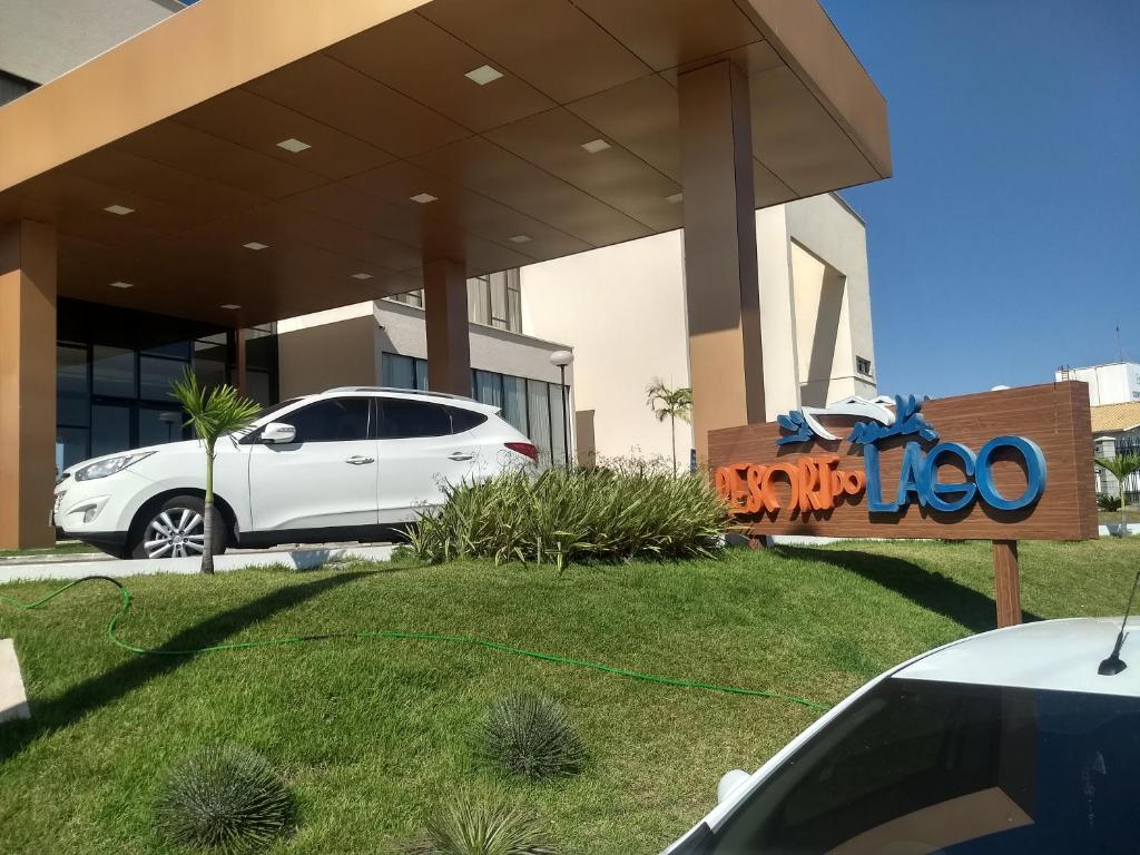 um carro branco estacionado em frente a um edifício em Resort do Lago em Caldas Novas