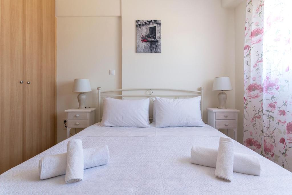 ein Schlafzimmer mit einem weißen Bett mit zwei weißen Kissen in der Unterkunft Lovely Apartment Xylokastro 2nd Floor in Xylokastro