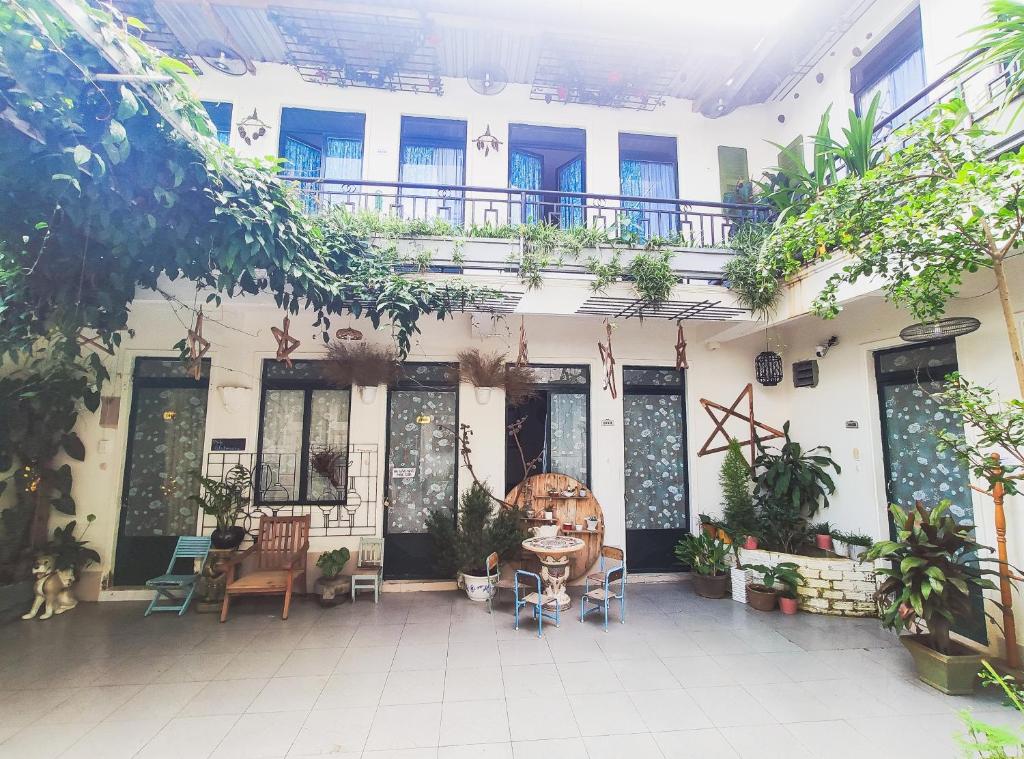 un patio de un edificio con mesa y sillas en Da Lat Lemongrass - Đà Lạt Sả en Dalat