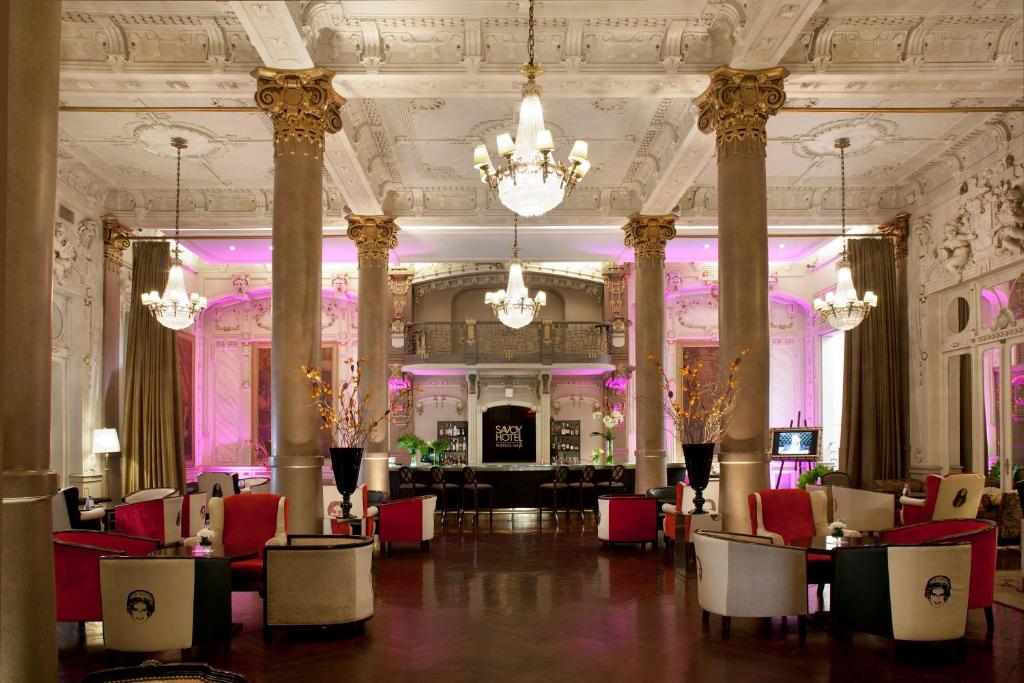 uma grande sala com cadeiras e mesas num edifício em Savoy Hotel em Buenos Aires