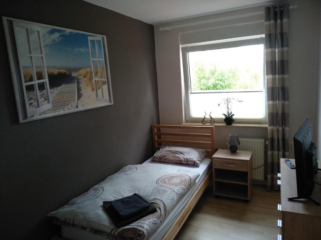 a small bedroom with a bed and a window at C. Wulf Gästezimmer in Bückeburg