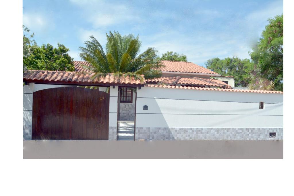 a house with a garage and a palm tree at Casa Piratininga Niterói Rj in Niterói