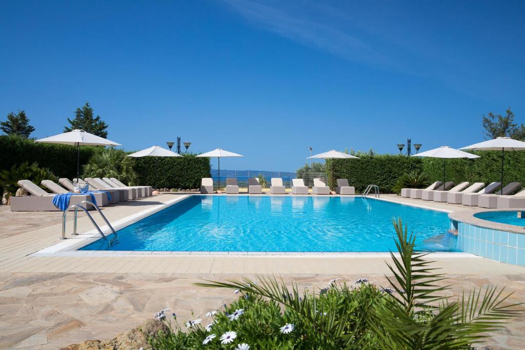 una piscina con sedie e ombrelloni in un resort di Lu' Hotel Porto Pino a SantʼAnna Arresi