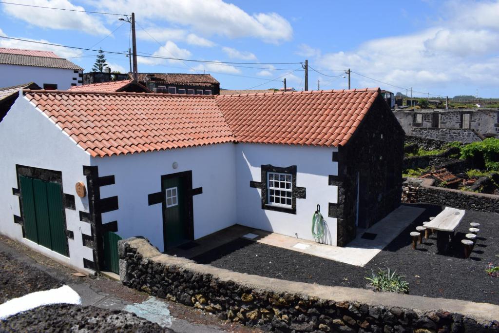 uma pequena casa branca com um telhado vermelho em Casinha da Avó Jerónima RRAL 1519 em Madalena