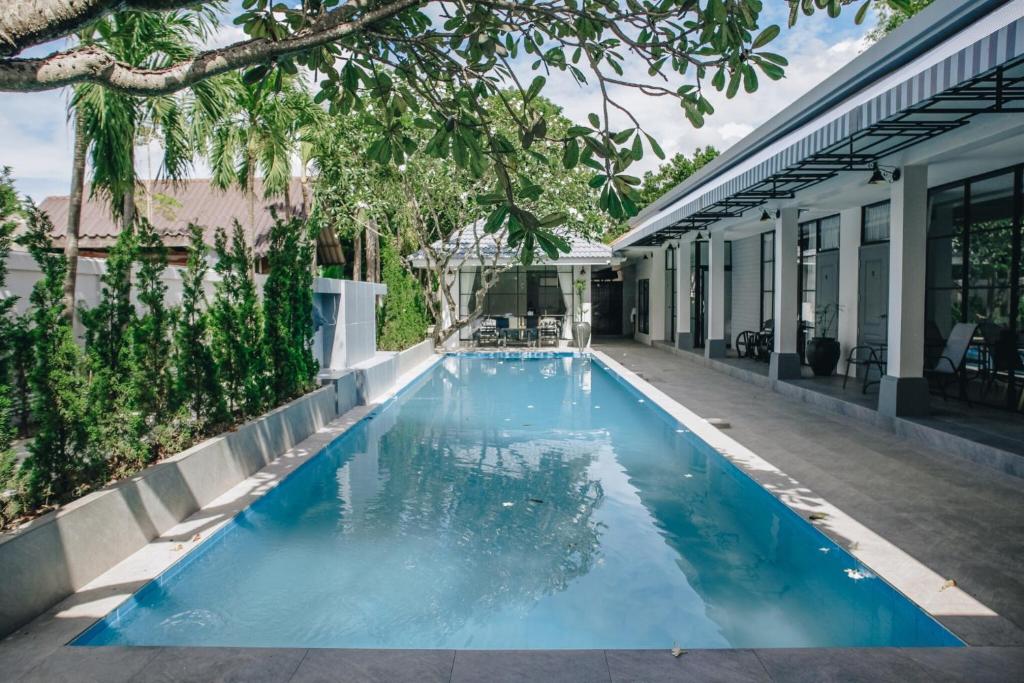 uma piscina no meio de uma casa em La Riva Boutique Hotel em Kamphaeng Phet