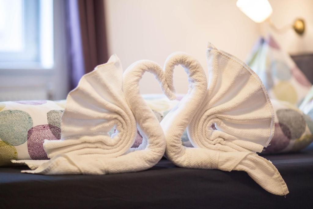 dos toallas con forma de cisnes sentados en una cama en City center Apartment, en Viena