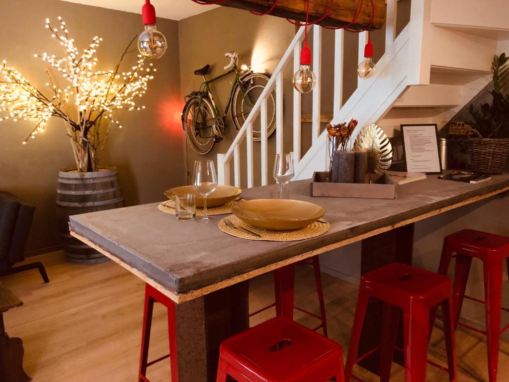 una mesa con taburetes rojos en una habitación con escaleras en Wieler Wellness Huuske en Spaubeek