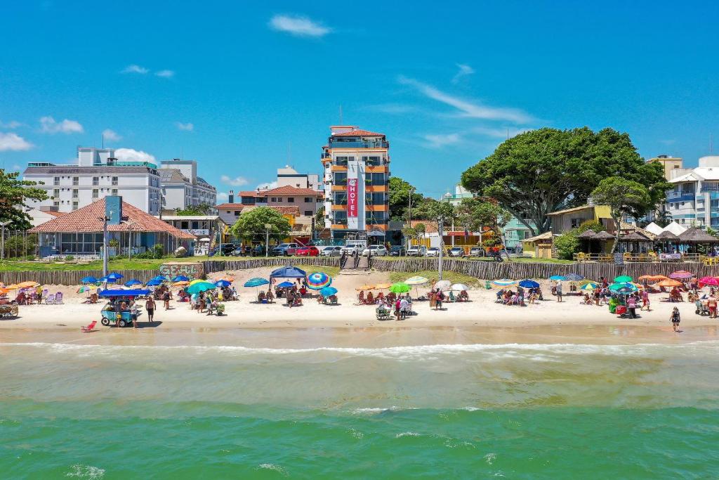 un grupo de personas en una playa con sombrillas en Hotel Vila Mar, en Florianópolis
