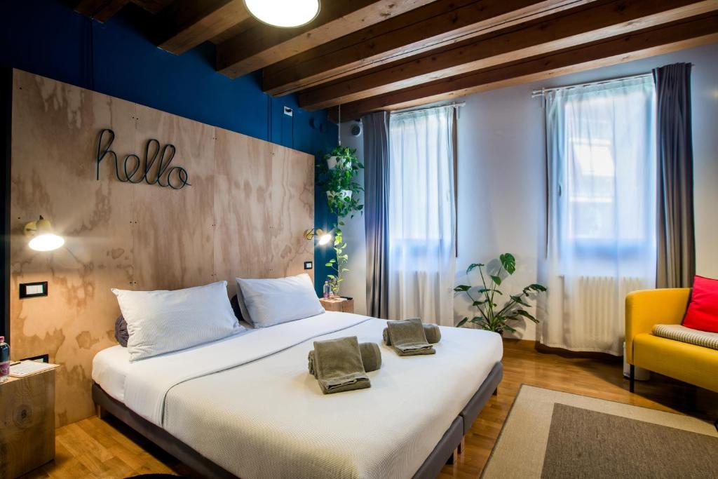 una camera con un grande letto e una sedia gialla di Castelmenardo39 a Treviso