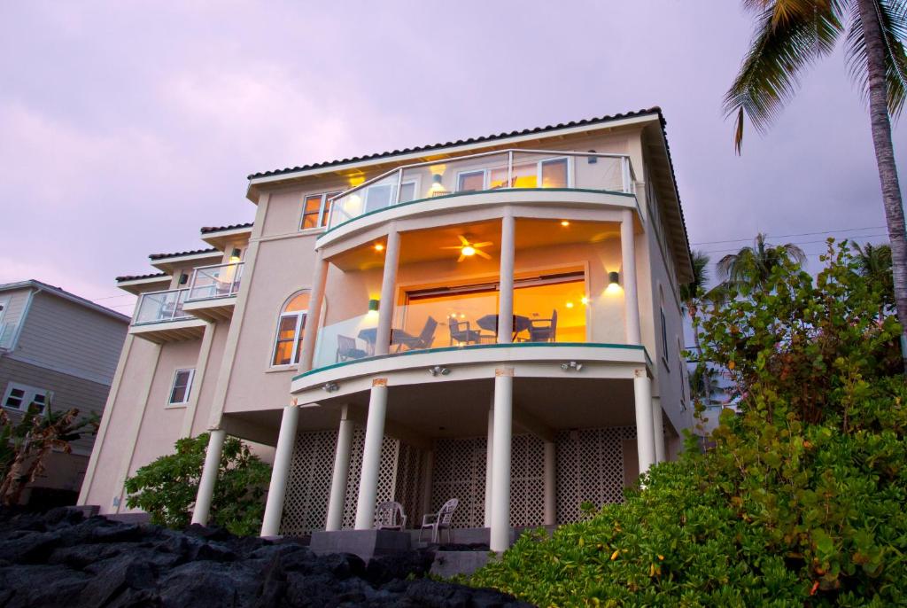 a large house with a balcony on top of it at Hale Honu - Spectacular Oceanfront Home w/ central A/C Wading Pool & Hottub in Kailua-Kona