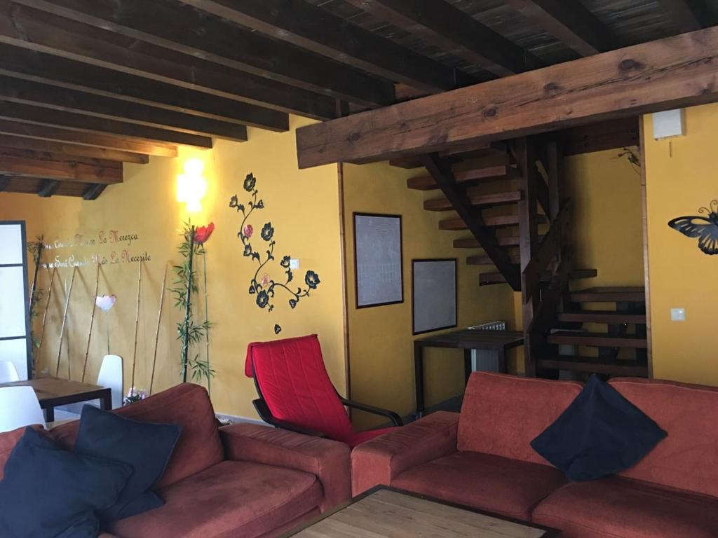 sala de estar con sofá y sillas rojas en CASA RURAL ANTONIO, en Martiherrero