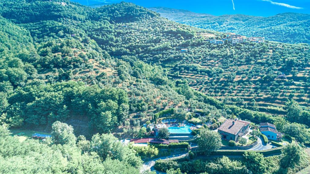 une vue aérienne sur une vallée avec des maisons et des arbres dans l'établissement " LE FORRI " società agricola, à Pistoia