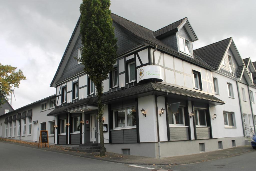 a white building with a black roof at Landhotel Schnier in Brilon