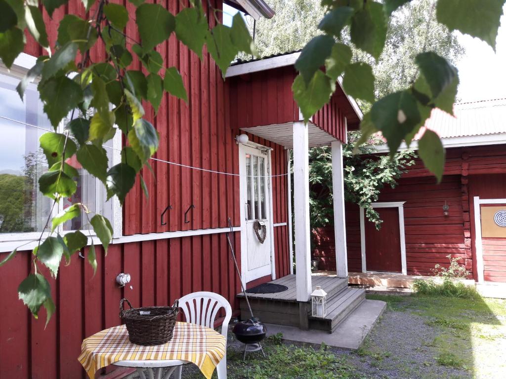uma casa vermelha com uma mesa e cadeiras em frente em Idyllinen kaksio em Kankaanpää