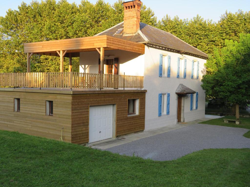 a house with a deck on top of it at Gite du verger in Mifaget