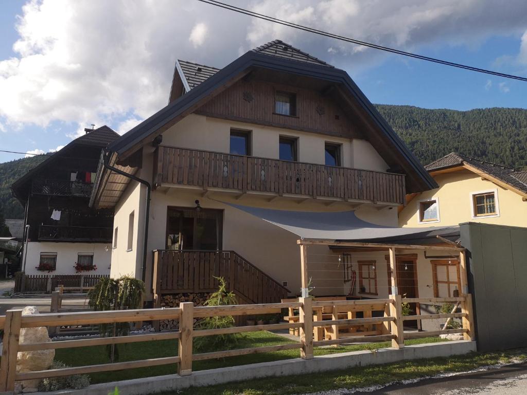 a house with a wooden fence in front of it at Hiša Pod gorami**** - house with wellness in Kranjska Gora
