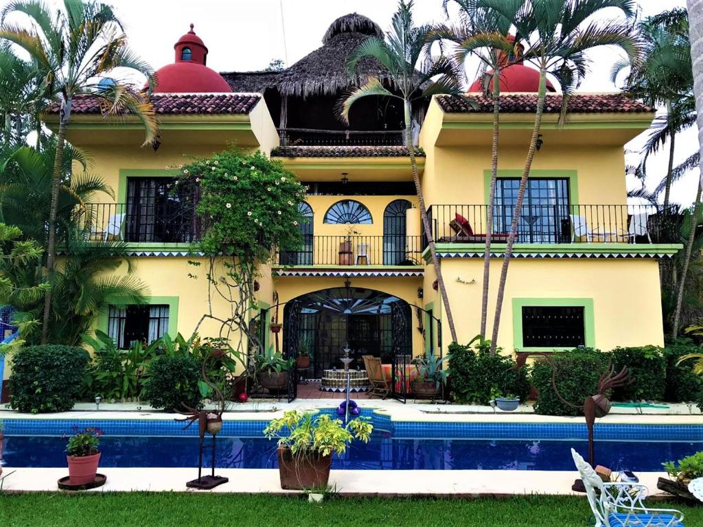 uma casa com uma piscina em frente em Casa Jardín del Tuito em El Tuito