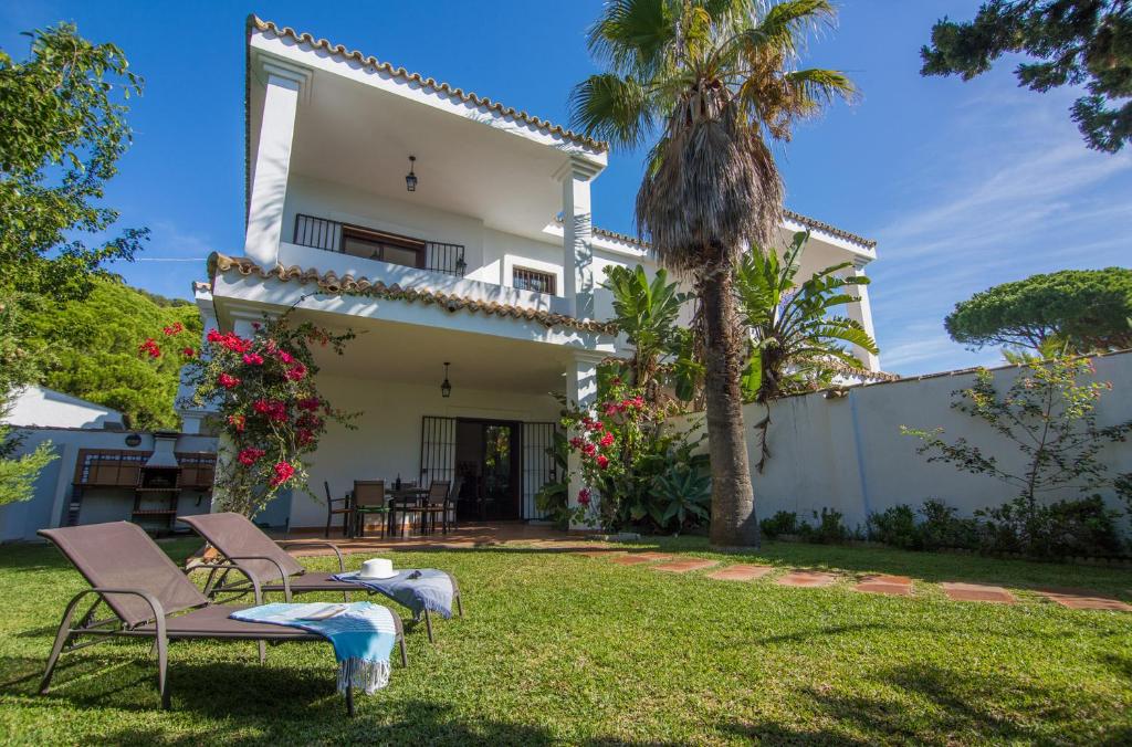 una casa con un cortile con due sedie e un tavolo di Casas Los 4 Soles a Los Caños de Meca