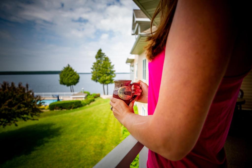 Westwood Shores Waterfront Resort في ستورغون باي: امرأة تحمل كأس من النبيذ